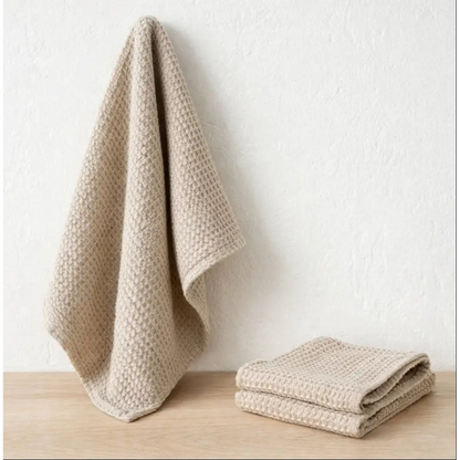 Beige textured towels on a wooden surface with a white background designed by Hemp Horizon