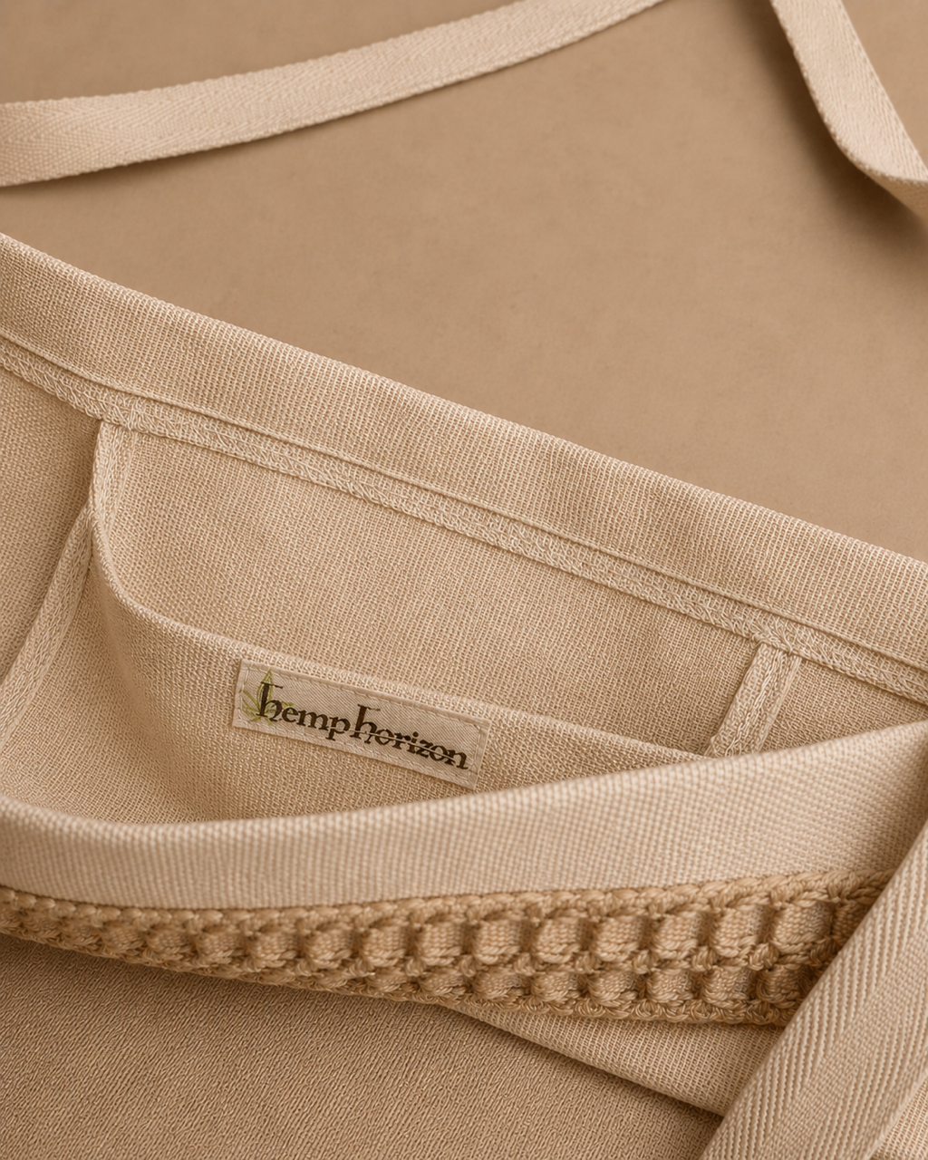 Close-up of a beige hemp tote with a visible sewn-in label reading 'hemphorizon' and a decorative textured trim detail on the internal pocket.